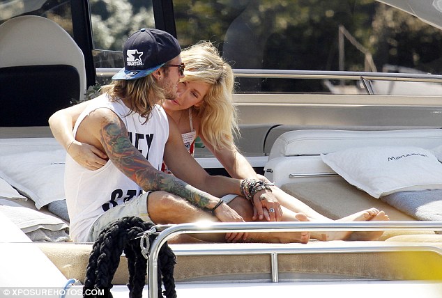 Loved-up: Ellie, 27, looked besotted with her rocker beau as she slung an arm over his shoulder and nuzzled his neck as they soaked up the rays