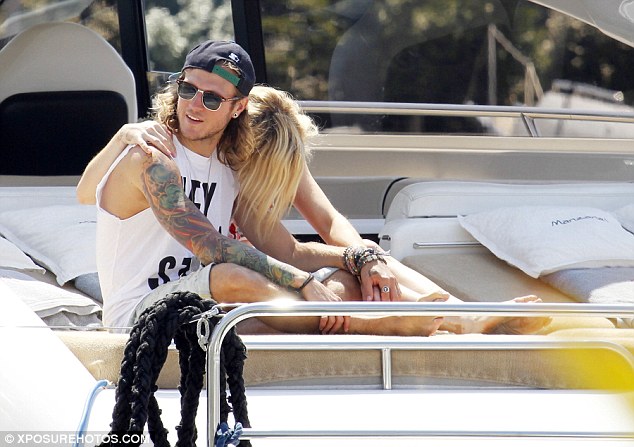 Rock star: He completed the look with a navy baseball cap, brown sunglasses and a khaki rucksack